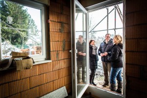 Nach Fertigstellung der Dachkonstruktion erfolgt der Einbau von Fenstern und Haustür. Bauherrenberaterin Giertz begutachtet die Anschlüsse im Bereich der Fensterlaibung und Rollladenkästen, prüft die Winkelverankerung der Türen auf dem Rohfußboden und die Qualität der Montage der Fensterbänke. Vom Ergebnis wird der Bauherr in Kenntnis gesetzt. Quelle: BSB e.V. Nach Fertigstellung der Dachkonstruktion erfolgt der Einbau von Fenstern und Haustür. Bauherrenberaterin Giertz begutachtet die Anschlüsse im Bereich der Fensterlaibung und Rollladenkästen, prüft die Winkelverankerung der Türen auf dem Rohfußboden und die Qualität der Montage der Fensterbänke. Vom Ergebnis wird der Bauherr in Kenntnis gesetzt. Quelle: BSB e.V.
