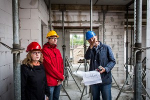 Bauherrenberater Weidemüller erläutert, dass die Trennwand aus statischen Gründen statt aus Porenbeton aus Kalksandstein gemauert werden muss. Foto: BSB e.V.