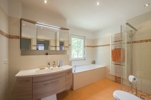 Ein Ort der Entspannung ist das geräumige Badezimmer mit Wanne und bodengleicher Dusche. Foto: Roth-Massivhaus/ Gerhard Zwickert
