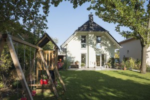 Ein wahres Spielparadies für die Kinder ist der Garten. Auf dem geschützten Freisitz auf der Terrasse kann die Familie ihr „Wohnzimmer im Grünen“ genießen. Foto: Roth-Massivhaus / Gerhard Zwickert