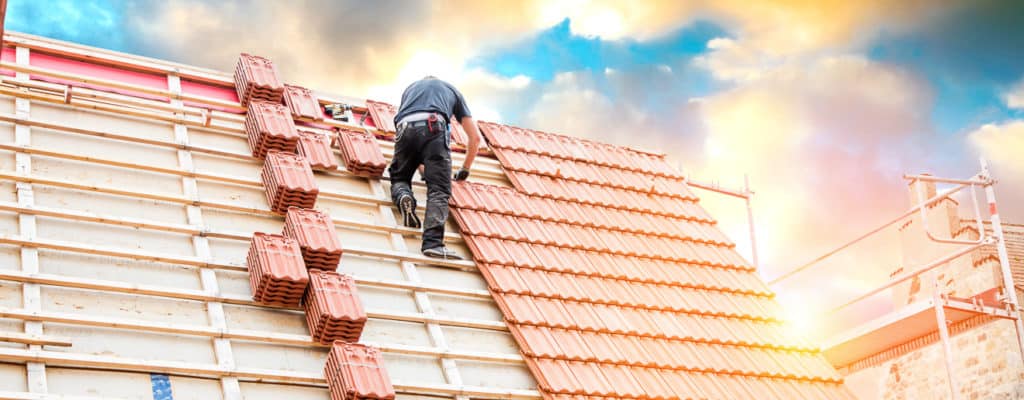 Dachdecker auf einem Spitzdach beim Dachdecken Foto: ©karepa - stock.adobe.com