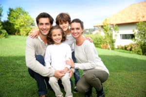 Glückliche Familien vor ihrem Haus