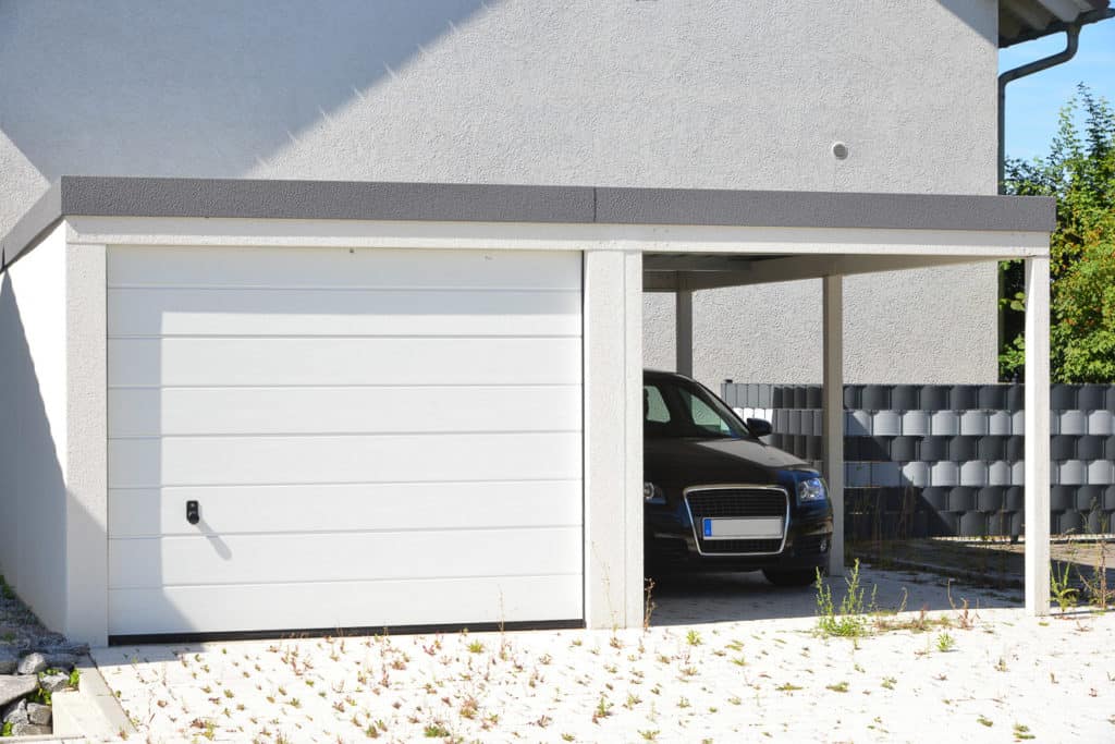 Moderne Fertiggarage mit Automatik-Tor und angebautem Carport