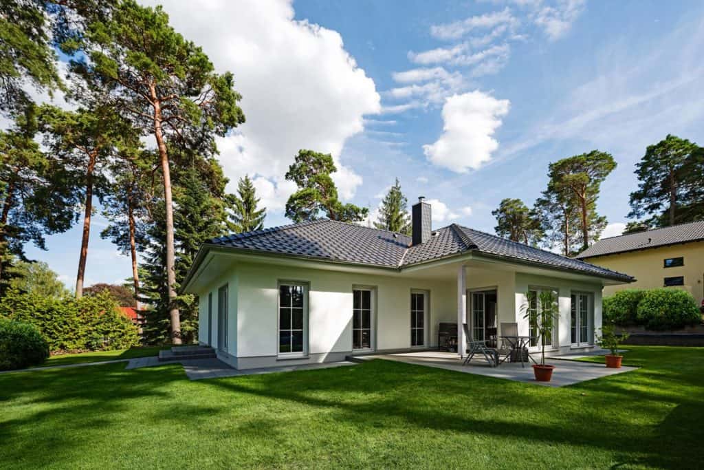 Auf einer Ebene mitten im Grünen wohnen: Der Winkelbungalow Ahlbeck mit seiner geschützten Terrasse gehört zu den beliebtesten Häusern von Roth-Massivhaus. 