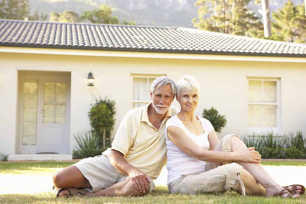 Glückliche Senioren vor dem Eigenheim